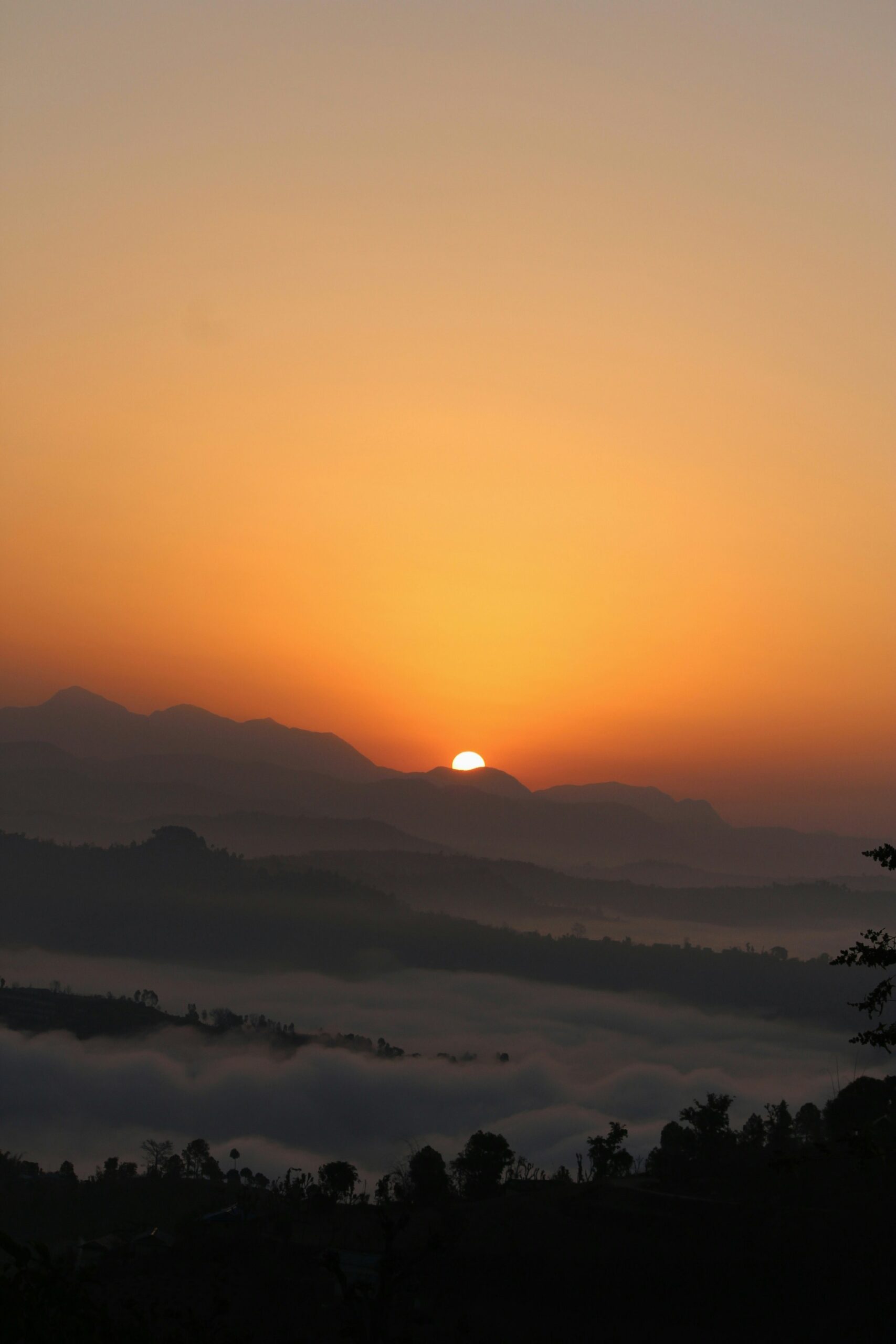 Golden sunlight over layered hills and misty valleys, illustrating scenery for the Nepal Tour Package.